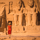 Elegant lady in a red dress marveling at the monumental Abu Simbel temples, organized by the premium DMC in Egypt.
