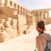 Woman exploring ancient ruins on sunny day.