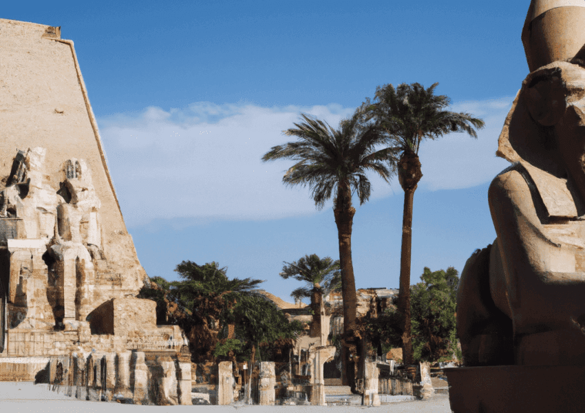 Ancient Egyptian temple with statues and palm trees.